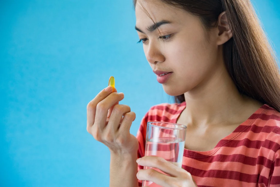 Individual holding an appetite-suppressant pill with a glass of water