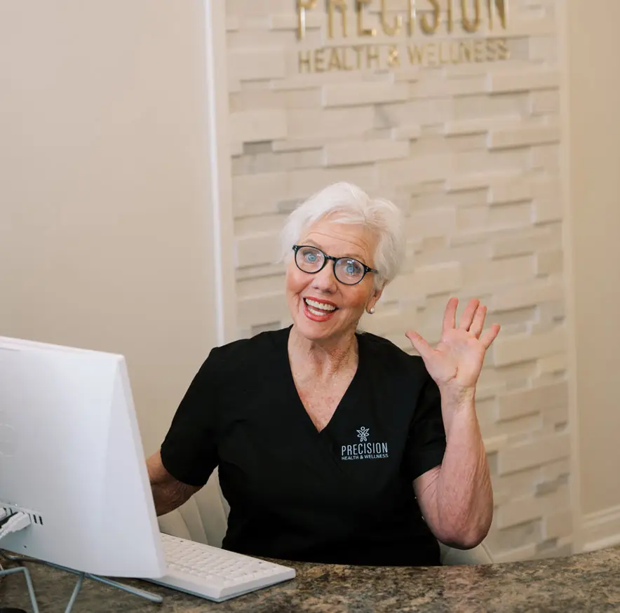 a woman waving at a computer