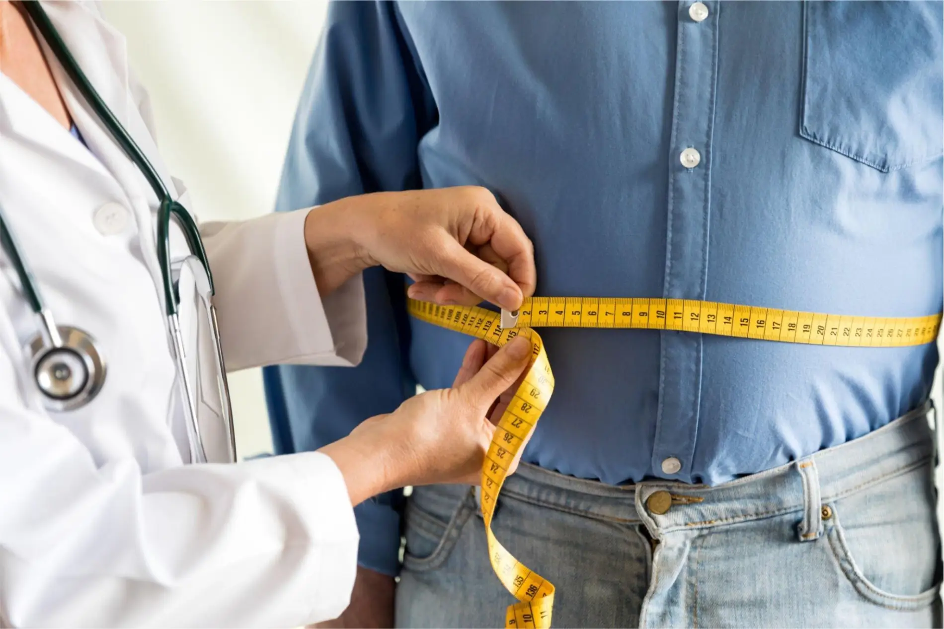 Doctor measuring a patient's waist circumference for health assessment