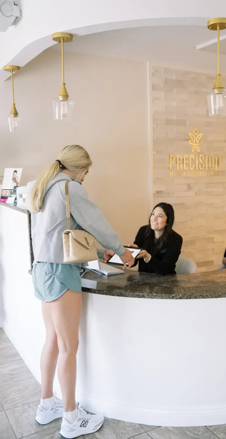 Reception area at Precision Health and Wellness with staff assisting a client