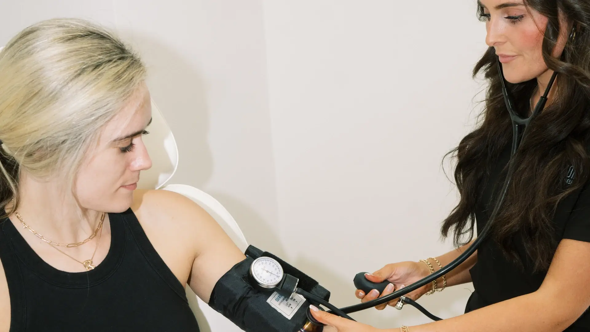 Precision Health professional checking patient's blood pressure for personalized wellness care.