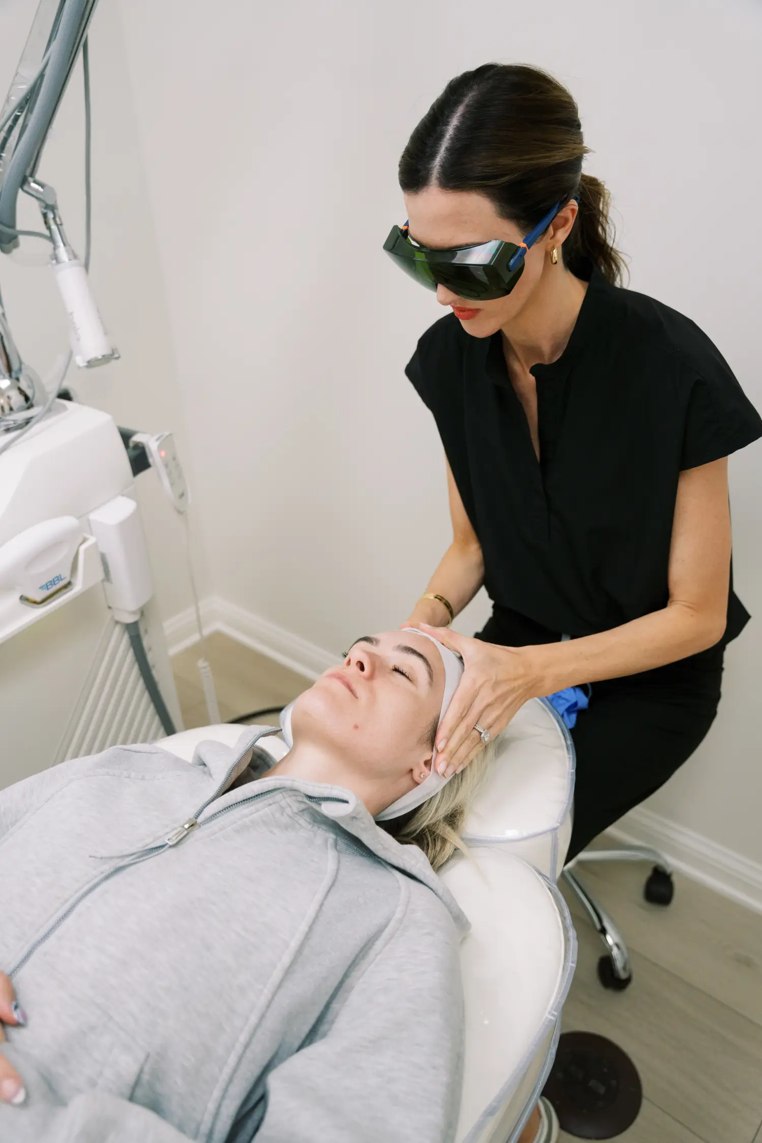 Skincare professional preparing patient for laser treatment.