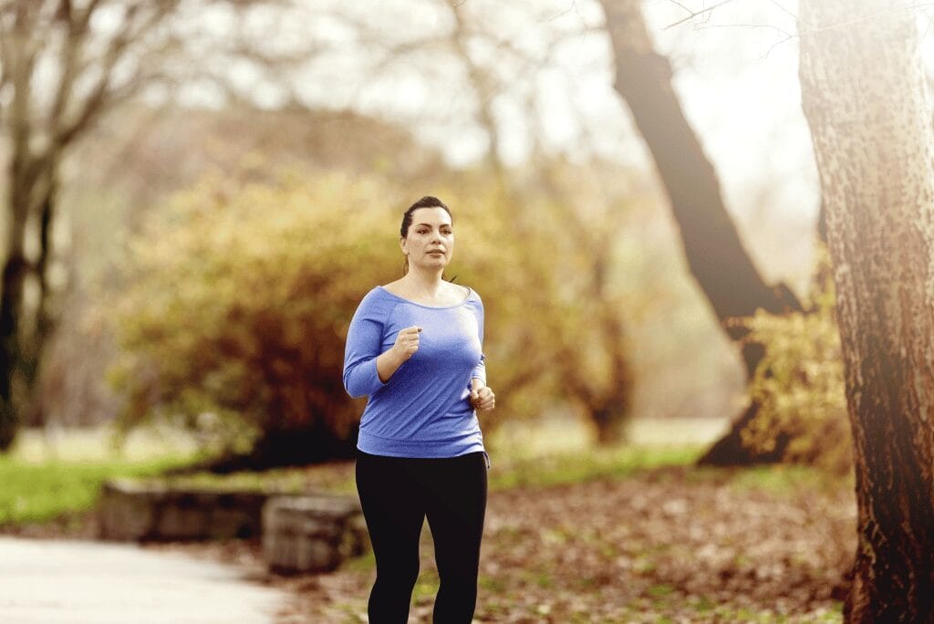 Middle-aged woman jogging in the park for healthy weight loss and hormone balance